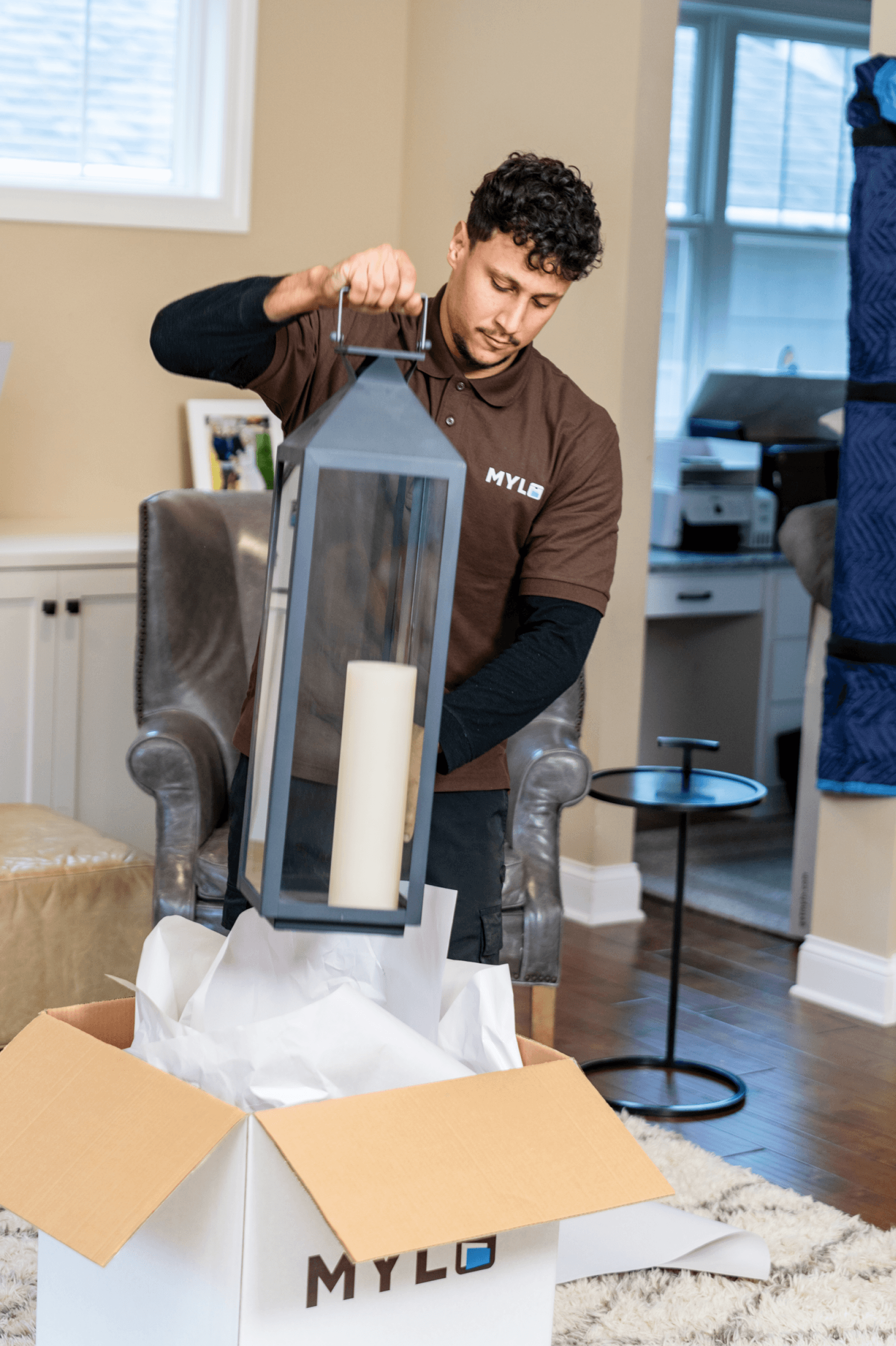 MYLO mover carefully packing a glass lantern into a box